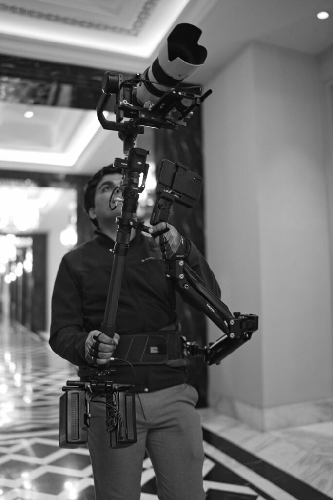 Steadicam operator with vest and arm rig in a hotel corridor