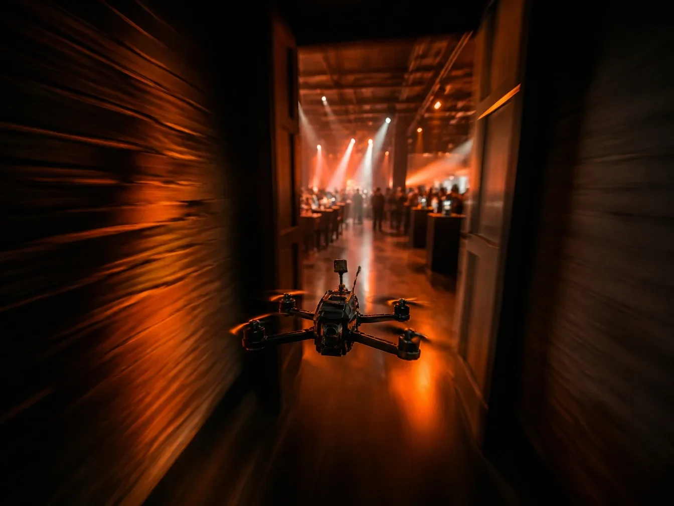 FPV drone flying through a doorway into an event hall